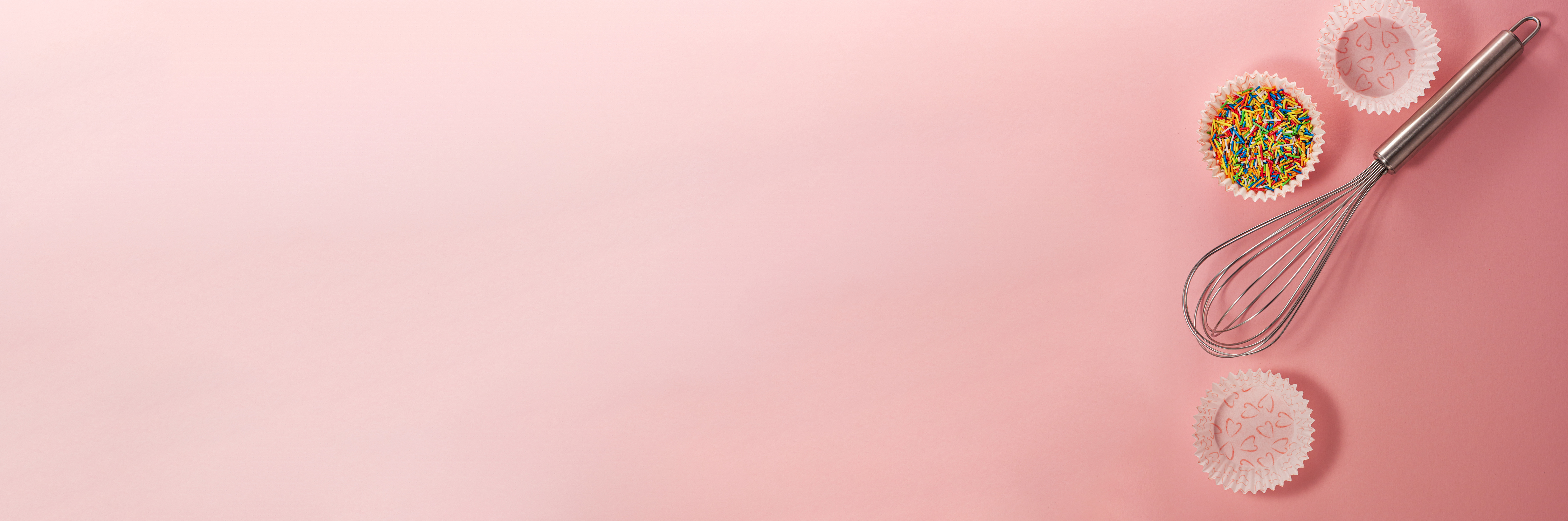 Banner of cupcake liners with colored sugar inside whisk